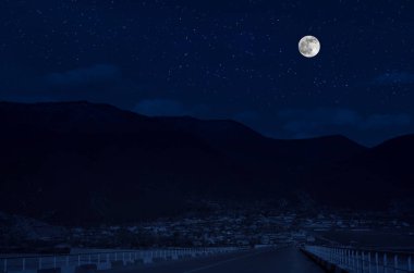 Dolunay gecesi ormanın içinden mountain road. Büyük ay ile gece ülke yol Manzara gece manzara. Uzun deklanşör fotoğrafı