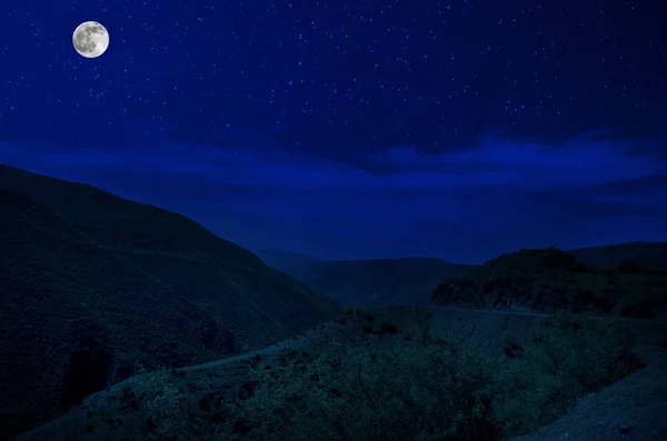 满月之夜穿过森林的山路。风景秀丽的乡村道路夜景,晚上与大月亮。长快门照片 — 图库照片