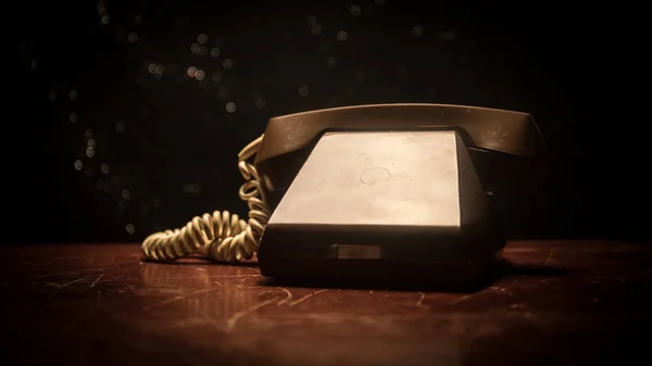 Oude zwarte telefoon op oude houten plank met kunst donkere achtergrond met mist en afgezwakt licht. lege ruimte — Stockfoto
