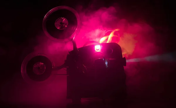 Projetor de filme vintage velho em um fundo escuro com nevoeiro e luz. Conceito de produção de filmes . — Fotografia de Stock