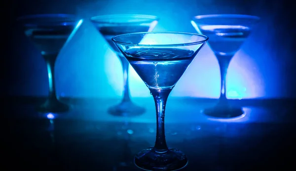 Martini cocktailglas girosaldi spatten op donker getinte rokerige achtergrond of een kleurrijke cocktail in glas met spatten en olijven. Partij club entertainment. Gemengd licht. Selectieve aandacht — Stockfoto