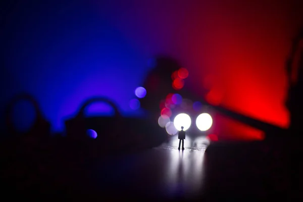 Legal law concept. Silhouette of handcuffs with The Statue of Justice on backside with the flashing red and blue police lights at foggy background. Selective focus — Stock Photo, Image