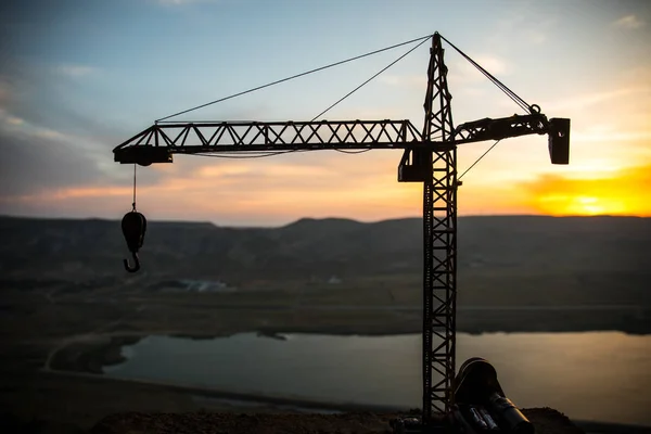 Resumo Fundo industrial com silhueta de guindaste de construção sobre incrível céu pôr do sol. Torre guindaste contra o céu da noite. Linha do horizonte industrial — Fotografia de Stock