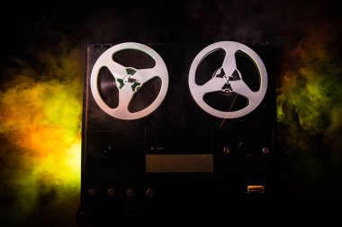 Koyu tonda sisli arka plan üzerinde makara oynatıcı ve kaydedici eski vintage makara. Makaralı Analog Stereo Açık Makara Bant Güverte Kaydedici Çalar.