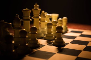 İş fikirleri ve rekabet Satranç tahtası oyun kavramı. Duman ve sis ile karanlık bir arka plan üzerinde Satranç rakamlar.