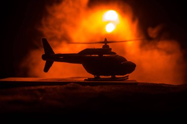 Askeri helikopter çatışma bölgesinden uçmaya hazır silüeti. Gece görüntüleri çöl sisli tonda sırt ile başlayarak helikopter ile dekore edilmiştir. Seçici odak.
