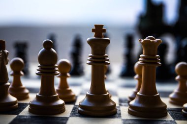 İş fikirleri ve rekabet Satranç tahtası oyun kavramı. Satranç tahtasındaki satranç figürleri. Açık gün batımı arka plan.