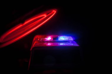 Geceleri polis arabaları. Polis arabası geceleri sis geçmişi olan bir arabayı kovalıyor. 911 Acil müdahale Seçici odak