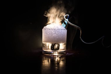 Koyu tonda sisli arka plan üzerinde bir fincan çay demlemek için Vintage elektrikli ısıtıcı. Hardal dan sonra bir bardak su ısıtma.