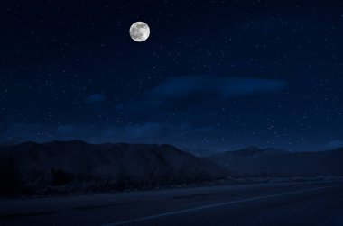 Dolunay gecesi ormanın içinden mountain road. Büyük ay ile gece ülke yol Manzara gece manzara. Uzun deklanşör fotoğrafı
