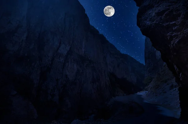 Bergsvägen genom skogen på en fullmåne natt. Natursköna Nattlandskap av landsväg på natten med stor Moon. Lång slutarbild — Stockfoto