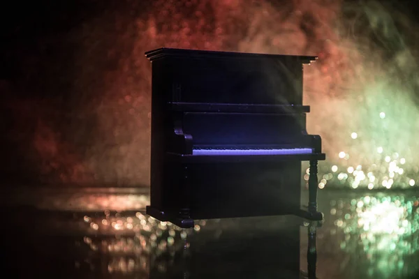 Concept créatif. Décoration d'oeuvre avec piano sur fond brumeux foncé avec lumière . — Photo