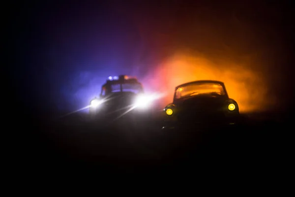 Auto della polizia a caccia di una macchina di notte con sfondo nebbia. 911 Auto della polizia di emergenza che accelera sulla scena del crimine. Focus selettivo — Foto Stock