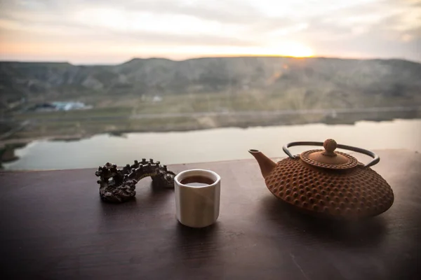 Koncept čaje. Japonská čajová ceremonie, východní nápoj. Čajník a šálky na stole s bambusovými listy při západu slunce — Stock fotografie