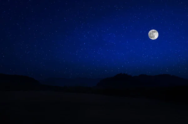 满月之夜穿过森林的山路。风景秀丽的乡村道路夜景,晚上与大月亮。长快门照片 — 图库照片