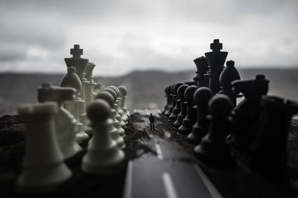 Концепция шахматной настольной игры бизнес-идей, конкуренции и стратегических идей. Шахматные фигуры на темном фоне с дымом и туманом. Селективный фокус — стоковое фото