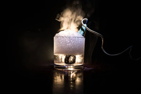 Vintage elektrische kachel voor het brouwen van thee in een kopje op donkere toned mistige achtergrond. Verwarmen van water in een glas na mosterd. — Stockfoto