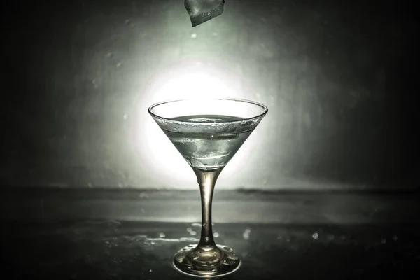 Martini koktél pohár a kezében a sötét tónusú füstös háttérben vagy színes koktél pohár fröccsenés-és olajbogyó fröccsenő. Party club szórakoztató. Vegyes fény. Szelektív összpontosít — Stock Fotó