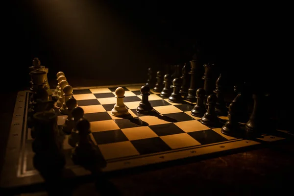 Chess board game concept of business ideas and competition. Chess figures on a dark background with smoke and fog. — Stock Photo, Image