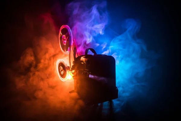 Oude vintage film projector op een donkere achtergrond met mist en licht. Concept van het maken van films. — Stockfoto