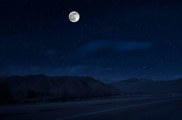 Mountain Road a través del bosque en una noche de luna llena. Paisaje nocturno escénico de carretera rural por la noche con luna grande. Fotografía del obturador largo — Foto de Stock