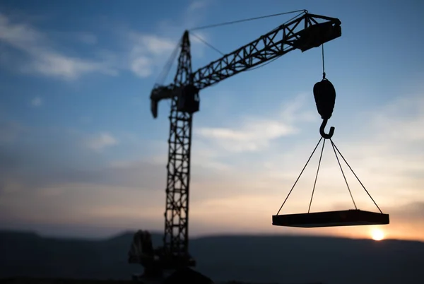 Resumo Fundo industrial com silhueta de guindaste de construção sobre incrível céu pôr do sol. Torre guindaste contra o céu da noite. Linha do horizonte industrial — Fotografia de Stock