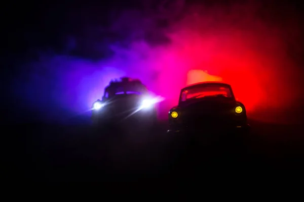 Coche de policía persiguiendo un coche por la noche con niebla de fondo. 911 Emergencia respuesta coche de policía exceso de velocidad a la escena del crimen. Enfoque selectivo —  Fotos de Stock