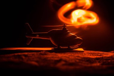 Askeri helikopter çatışma bölgesinden uçmaya hazır silüeti. Gece görüntüleri çöl sisli tonda sırt ile başlayarak helikopter ile dekore edilmiştir. Seçici odak.