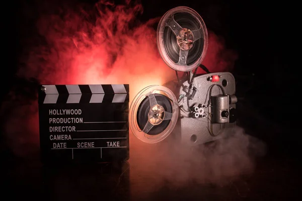 Oude vintage film projector op een donkere achtergrond met mist en licht. Concept van het maken van films. — Stockfoto