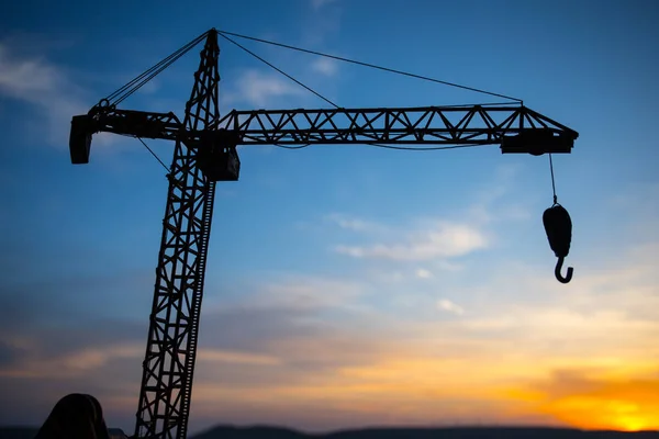 Resumo Fundo industrial com silhueta de guindaste de construção sobre incrível céu pôr do sol. Torre guindaste contra o céu da noite. Linha do horizonte industrial — Fotografia de Stock