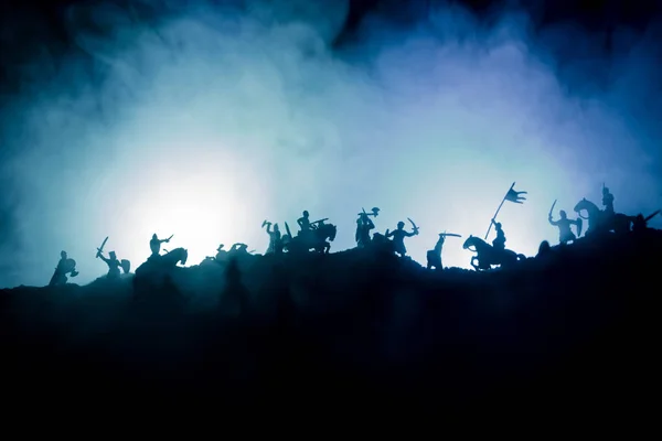 Cena de batalha medieval com cavalaria e infantaria. Silhuetas de figuras como objetos separados, luta entre guerreiros em fundo enevoado tonificado escuro com castelo medieval . — Fotografia de Stock