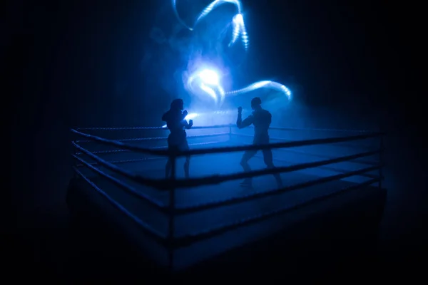 Man and woman boxing on the ring. Sport concept. Artwork decoration with foggy toned dark background.