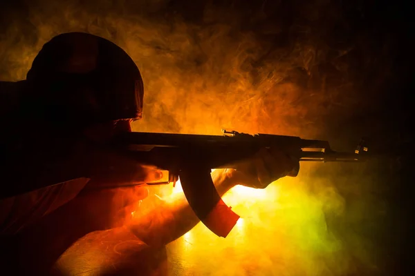 Silhouette av man med Assault Rifle redo att attackera på mörkt tonas dimmigt bakgrund eller farlig bandit Holding Gun i handen. — Stockfoto