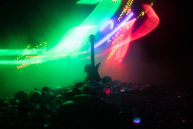 Müzik konsepti. Akustik gitar ile kopya alanı dumanla ışık demeti altında karanlık bir arka plan üzerinde izole. Gitar telleri, yakın çekim. Seçici odak. Etkileri ateş. Gerçeküstü gitar