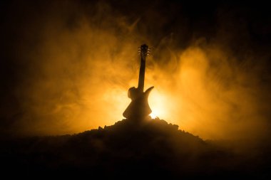 Müzik konsepti. Akustik gitar ile kopya alanı dumanla ışık demeti altında karanlık bir arka plan üzerinde izole. Gitar telleri, yakın çekim. Seçici odak. Etkileri ateş. Gerçeküstü gitar