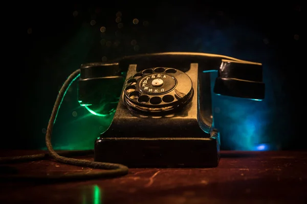 Vieux téléphone noir sur vieille planche de bois avec fond sombre art avec brouillard et lumière tonique. espace vide — Photo