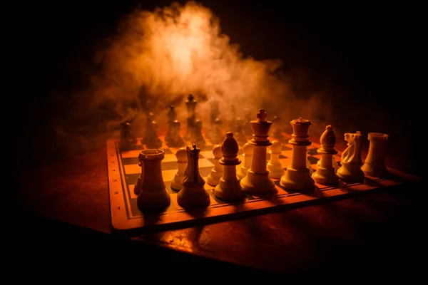 Juego de mesa de ajedrez concepto de ideas de negocio y competencia. Figuras de ajedrez sobre un fondo oscuro con humo y niebla . —  Fotos de Stock