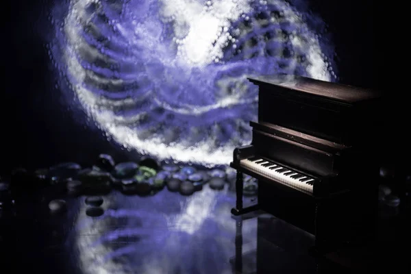 Creative concept. Artwork decoration with piano on dark toned foggy background with light.