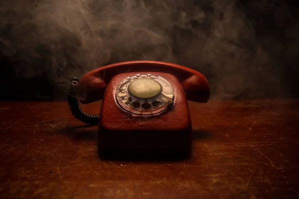 Telefone preto velho na tábua de madeira velha com arte fundo escuro com nevoeiro e luz tonificada. espaço vazio — Fotografia de Stock