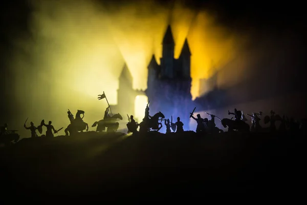 Medieval battle scene with cavalry and infantry. Silhouettes of figures as separate objects, fight between warriors on dark toned foggy background with medieval castle. — Stock Photo, Image