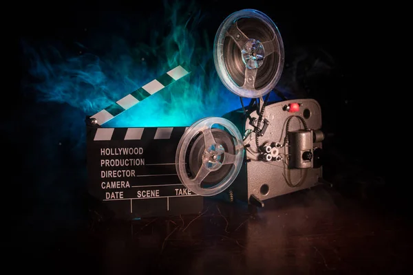 Oude vintage film projector op een donkere achtergrond met mist en licht. Concept van het maken van films. — Stockfoto