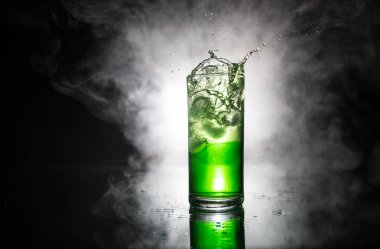 Kokteyl cam koyu tonda dumanlı arka plan veya cam renkli kokteyl sıçrayan. Parti kulübü eğlencesi. Karışık ışık.