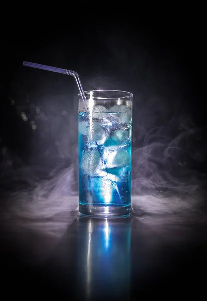 Sklenička z koktejlového skla na tmavém, zakouřené pozadí nebo barevný koktejl ve skle. Party v klubu. Smíšené světlo. — Stock fotografie
