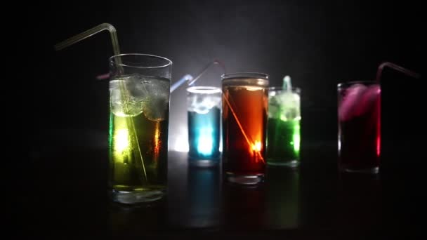 Cinco cocktails no bar com fumo no fundo escuro. Amarelo, verde e azul óculos coloridos . — Vídeo de Stock