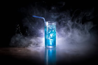 Kokteyl cam koyu tonda dumanlı arka plan veya cam renkli kokteyl sıçrayan. Parti kulübü eğlencesi. Karışık ışık.
