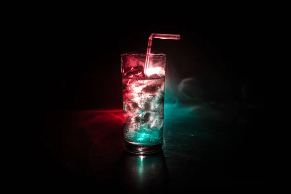 Cocktail glas spetteren op donkere toned rokerige achtergrond of kleurrijke cocktail in glas. Party Club entertainment. Gemengd licht. — Stockfoto