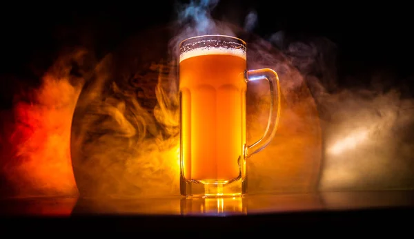 Concepto creativo. Vasos de cerveza sobre mesa de madera en fondo nebuloso tonificado oscuro . — Foto de Stock