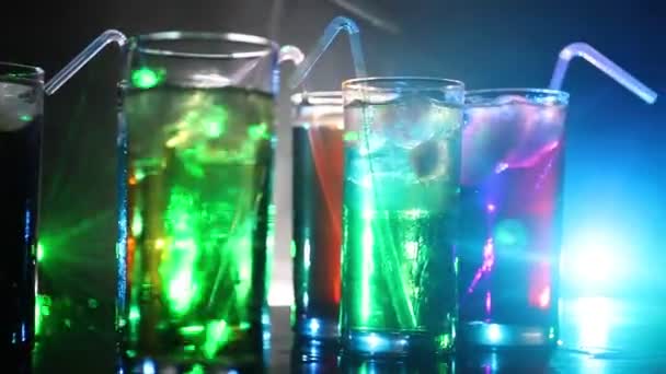 Cinco cocktails no bar com fumo no fundo escuro. Amarelo, verde e azul óculos coloridos . — Vídeo de Stock