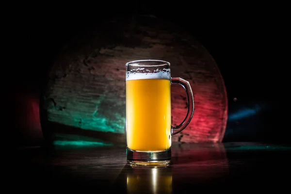 Conceito criativo. copos de cerveja na mesa de madeira no fundo enevoado tonificado escuro . — Fotografia de Stock