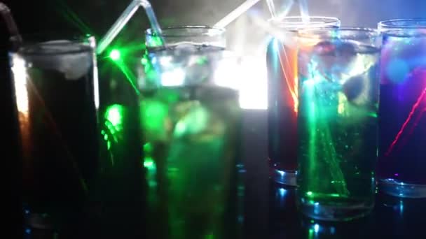 Cinq cocktails au bar avec de la fumée sur fond sombre. Lunettes jaunes, vertes et bleues . — Video